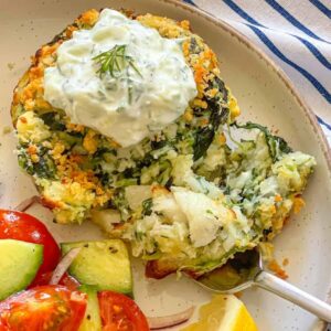 fish cake cut open on a plate and garnished with creamy sauce.