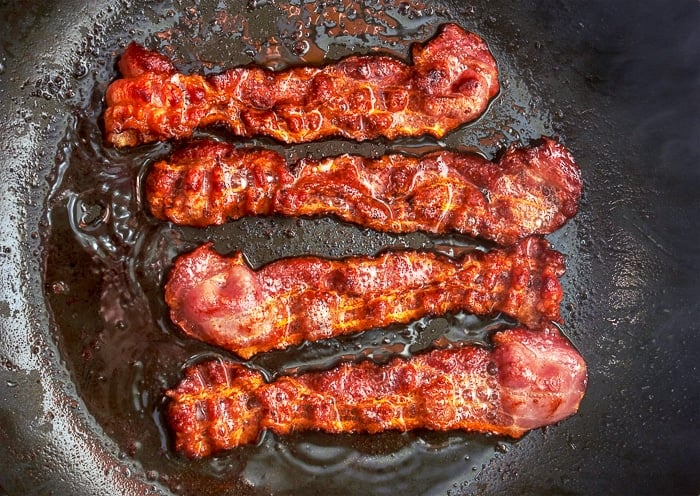 Tranche de bacon cuite dans une poêle. Gros plan.