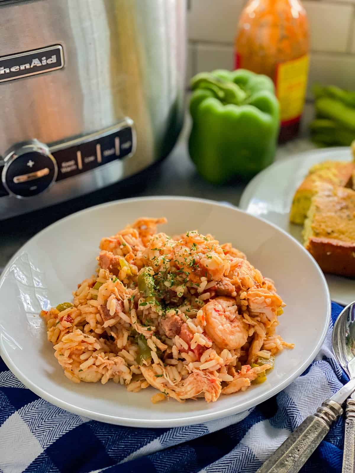 Bol circulaire blanc rempli de crevettes, de poulet et de riz avec du pain de maïs à part.