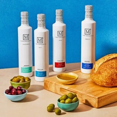 Le lot d'huile d'olive extra vierge de tous les jours de la boutique Mediterranean Dish comprend deux 3 bols d'olives et un plateau en bois avec une miche de pain et un bol d'huile d'olive.