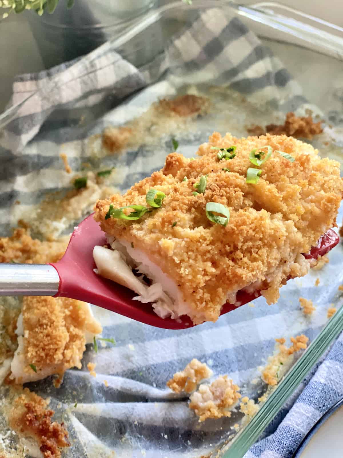 Spatule rouge avec un morceau de poisson pané dessus.