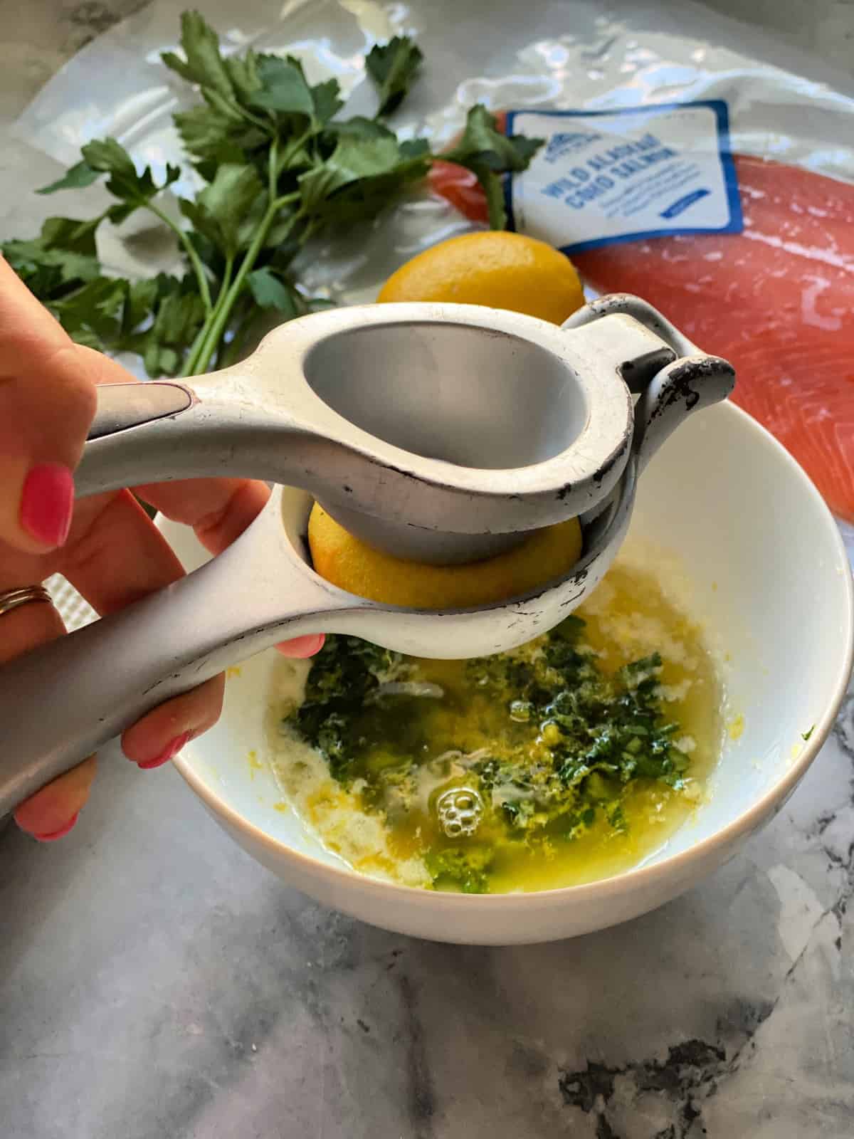 Pressez à la main le jus de citron dans un bol avec le beurre et le persil à côté du paquet de saumon.