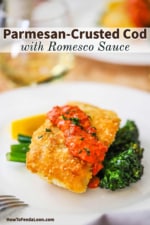 Une assiette blanche remplie de morue en croûte de parmesan et de romesco reposant sur des broccolini sautés.