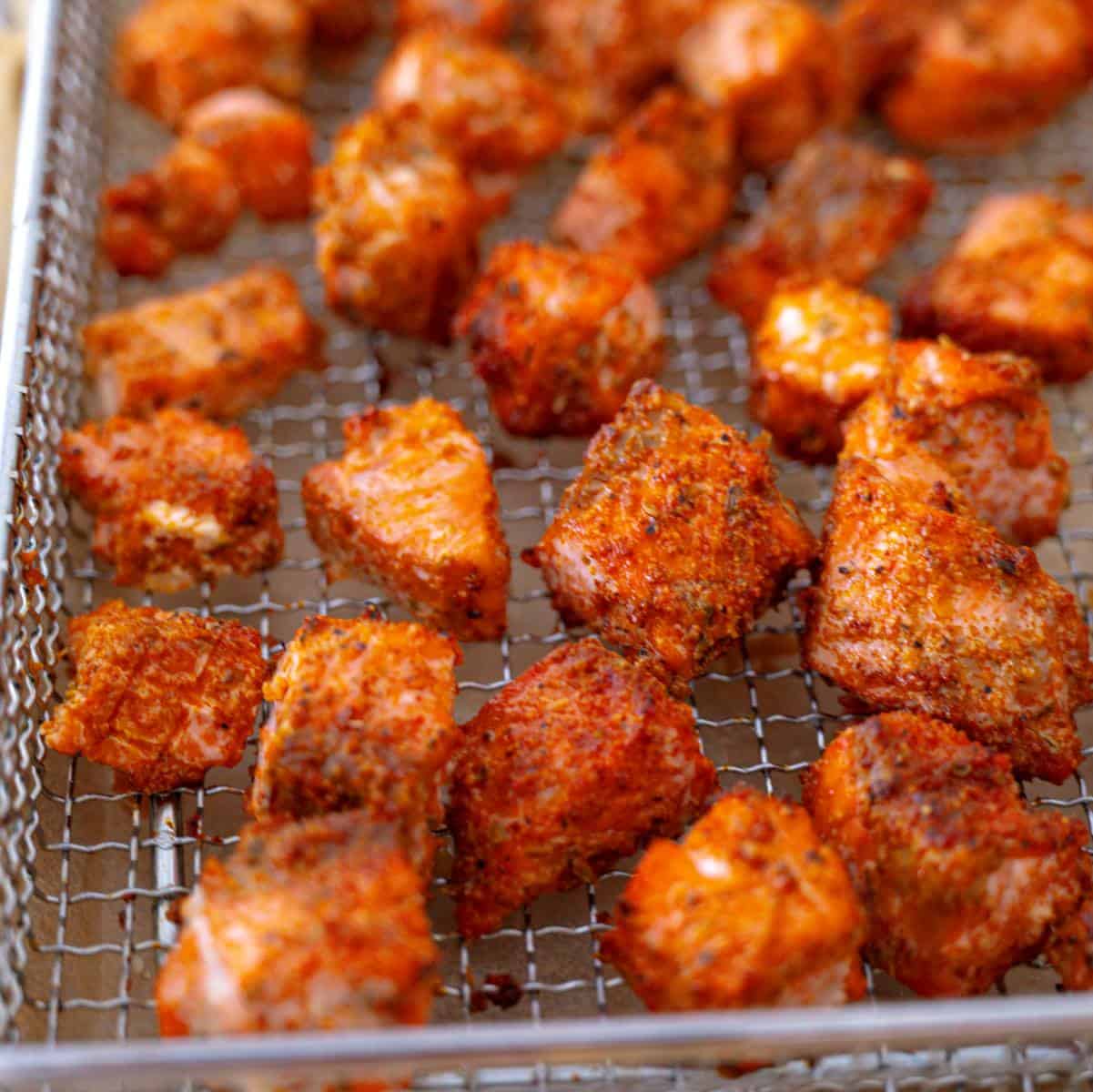 bouchées de saumon croustillantes sur une grille de friteuse à air prêtes à servir.