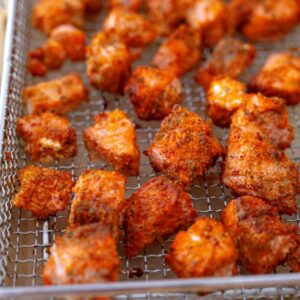 Golden crispy air fried salmon bites on a wire rack, ready to serve.